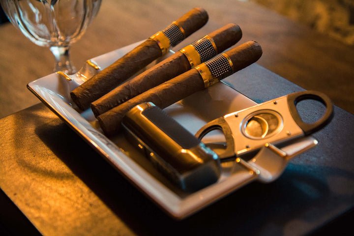 Cigars in ashtray with cutter and lighter